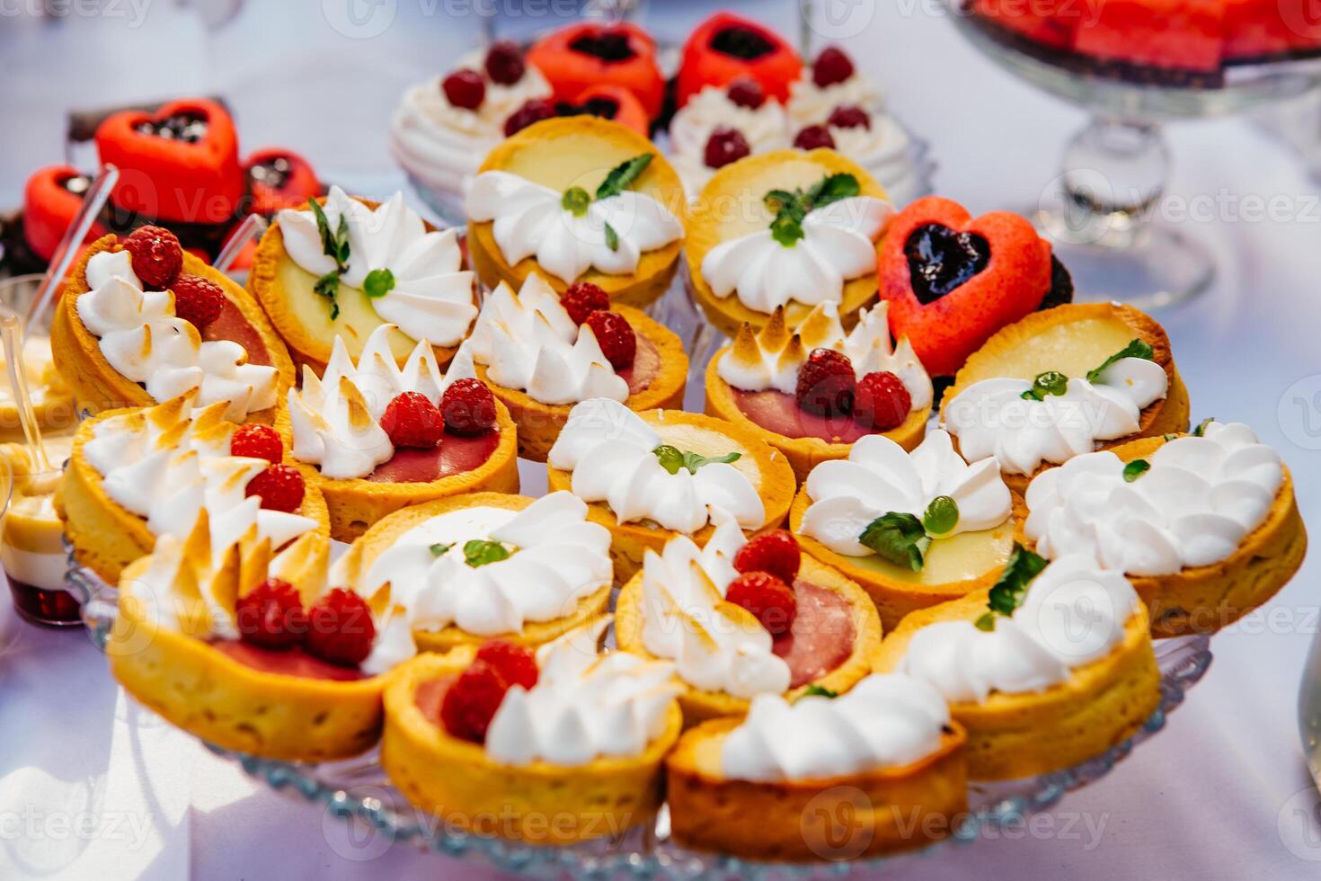 Sweet table with fruit cakes with cream and sweetness on holiday background. Delicious candy bar. Wedding candy bar service photo