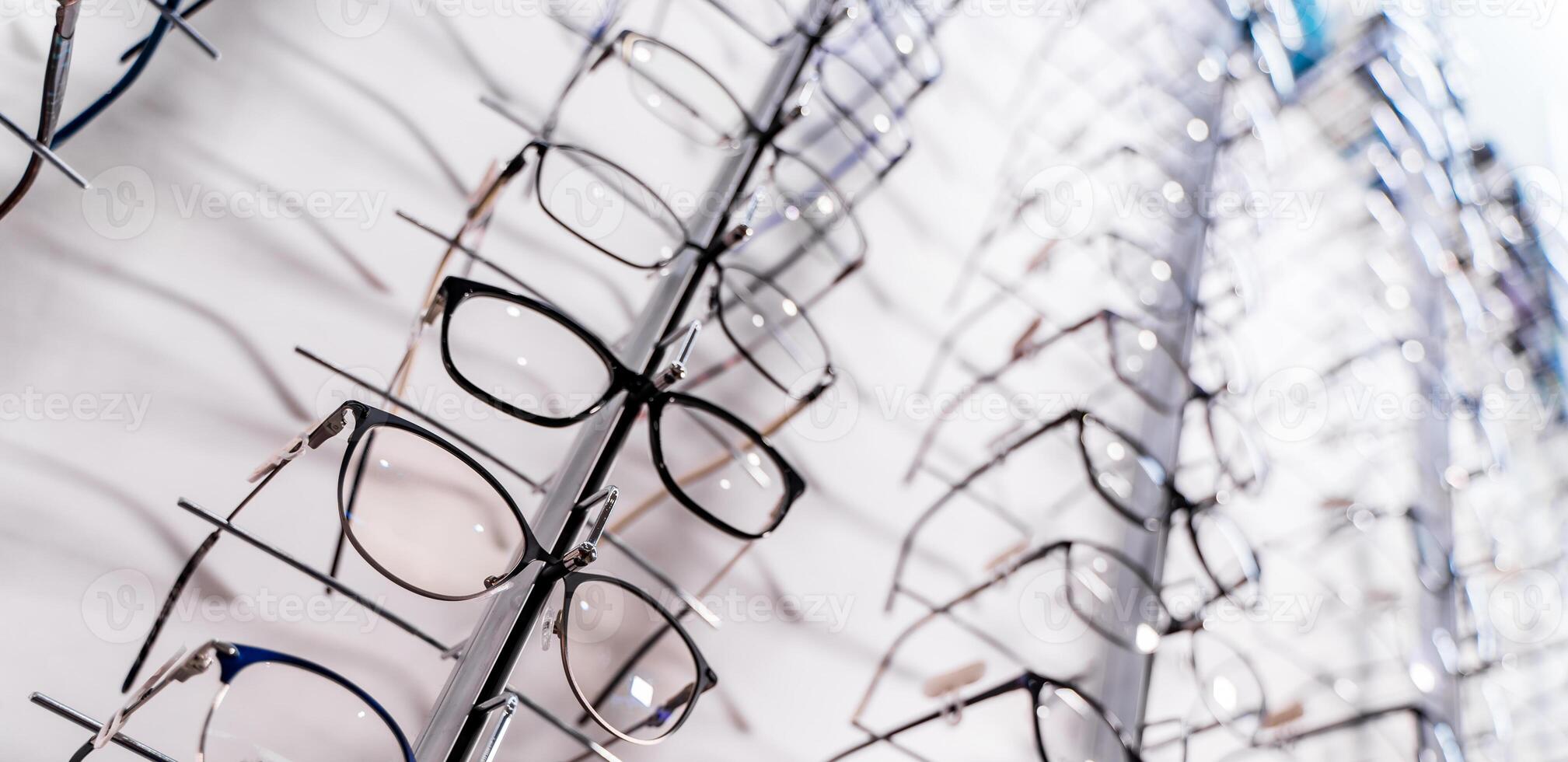 Glasses on display on wall in store. Showcase with spectacles in modern ophthalmic store. photo