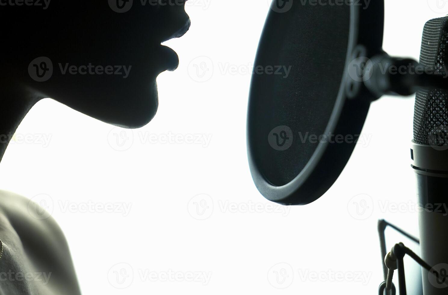 Portrait of young woman recording a song in a professional studio. Black and White. photo