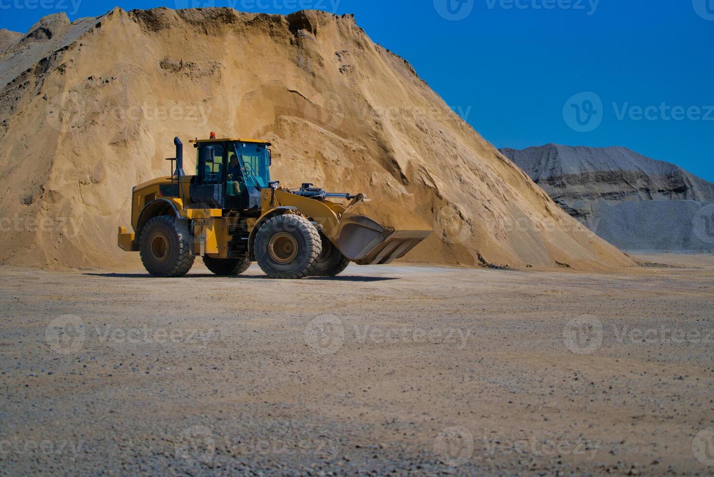 amarillo excavador en un construcción sitio en contra azul cielo foto