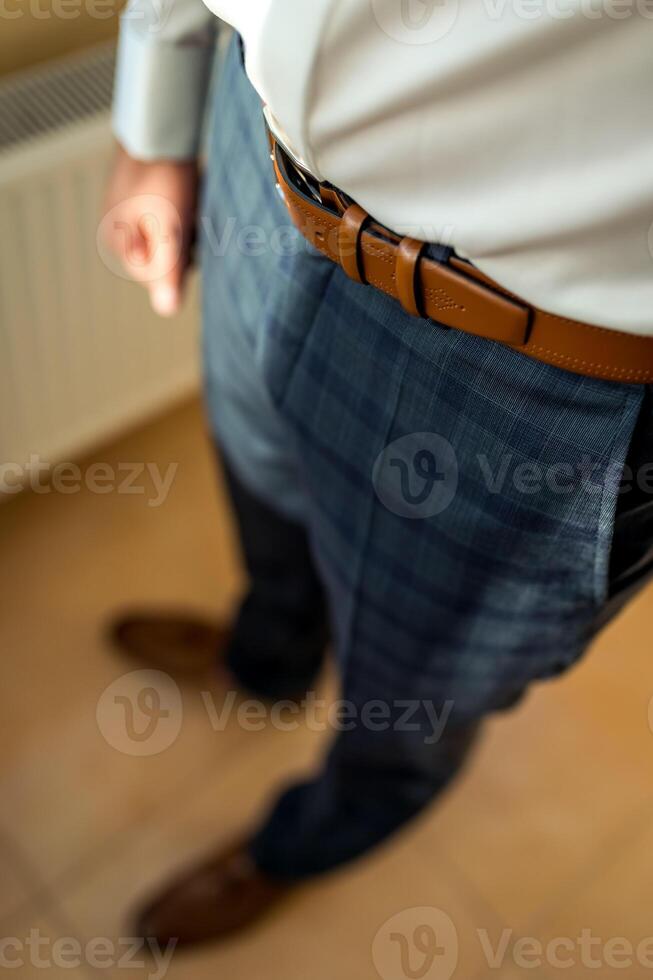 novio sesión de fotos. hombre en a cuadros traje. Boda día. elegante novio en blanco camisa . foto