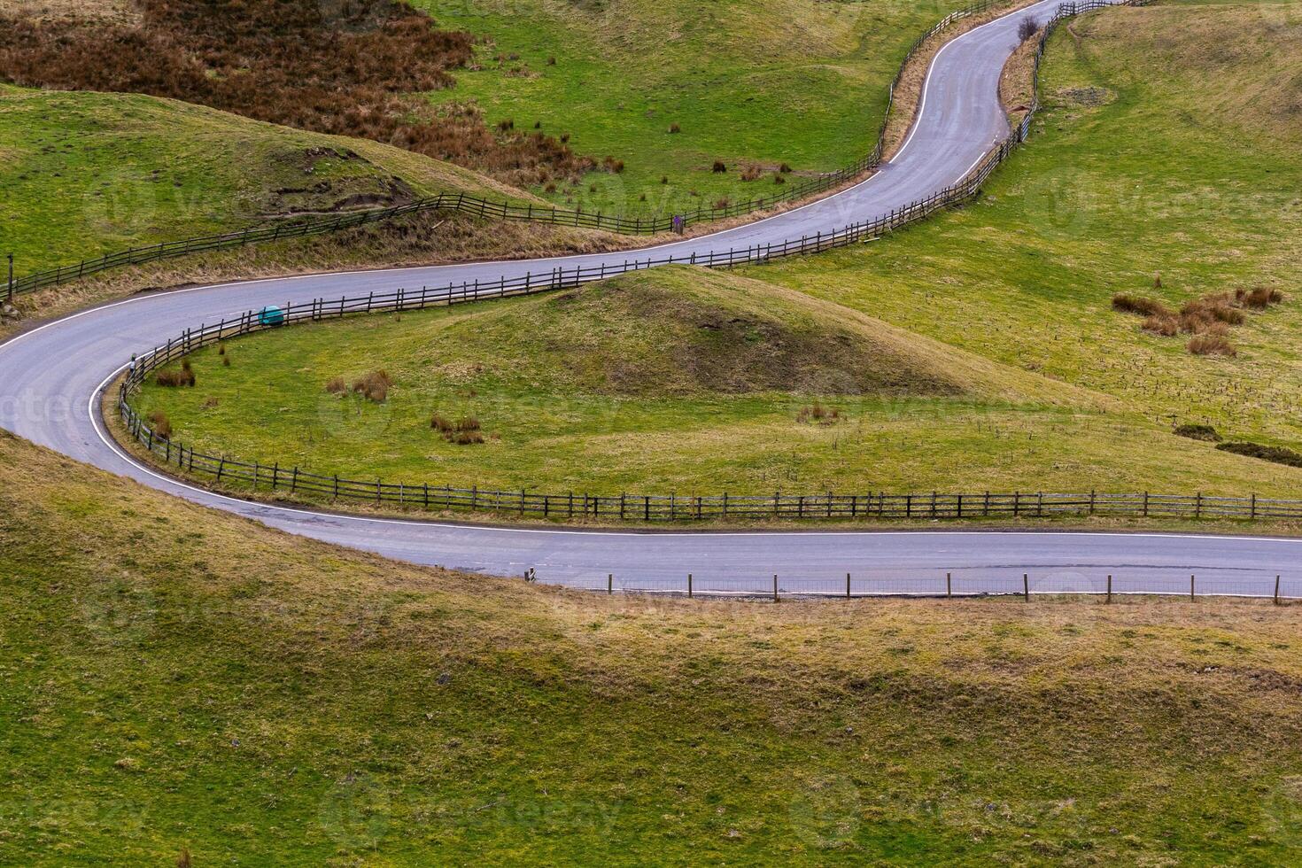 Winding country road through green hills, showcasing rural landscape and travel concept in Peak District, England. photo