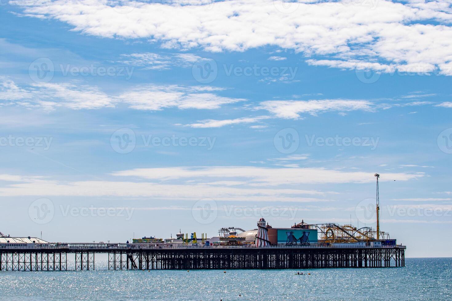Seaside pier with amusement park under a cloudy sky in Brighton, England. photo