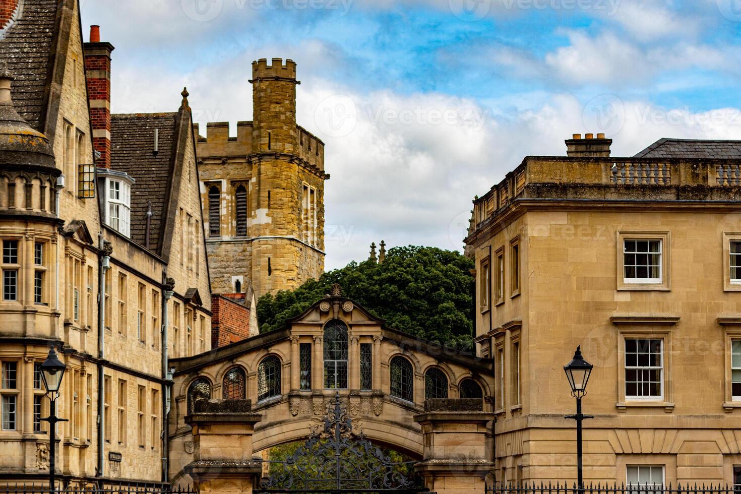 Historic European architecture with stone buildings and a tower under a cloudy sky in Oxford, England. photo