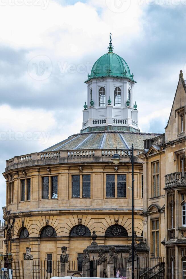 Historic building with a green dome under a cloudy sky, showcasing classic architecture in an urban setting in Oxford, England. photo