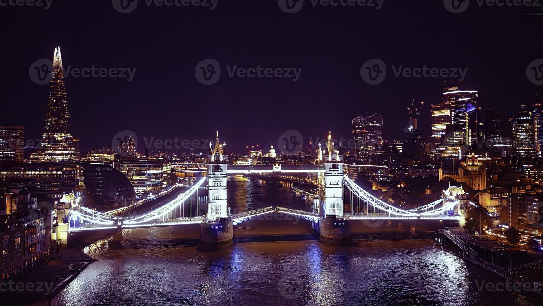 Scenic aerial view of the Tower Bridge and city at night in London photo