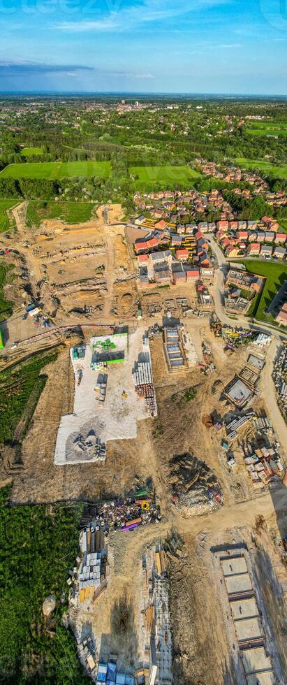 Aerial view of a construction site with machinery and partially built structures, surrounded by greenery. photo