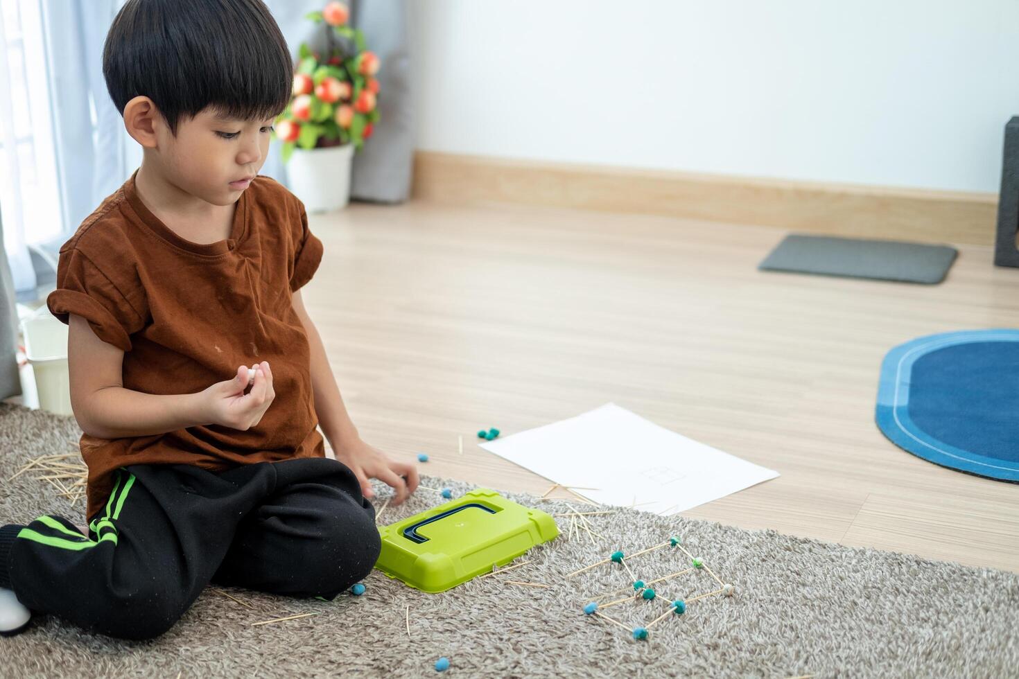 Asian boy playing with plasticine in the room photo
