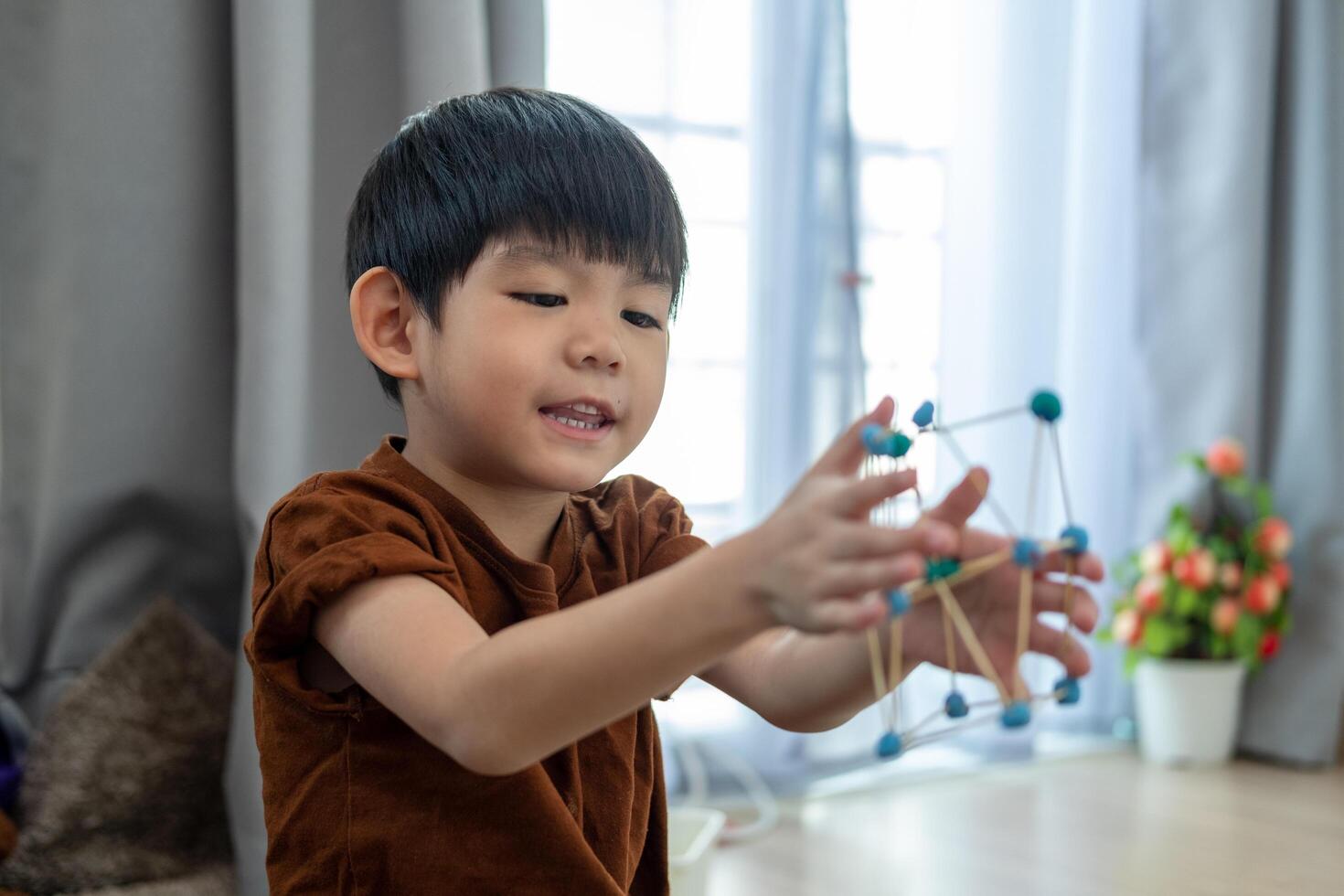 Asian boy playing with plasticine in the room photo