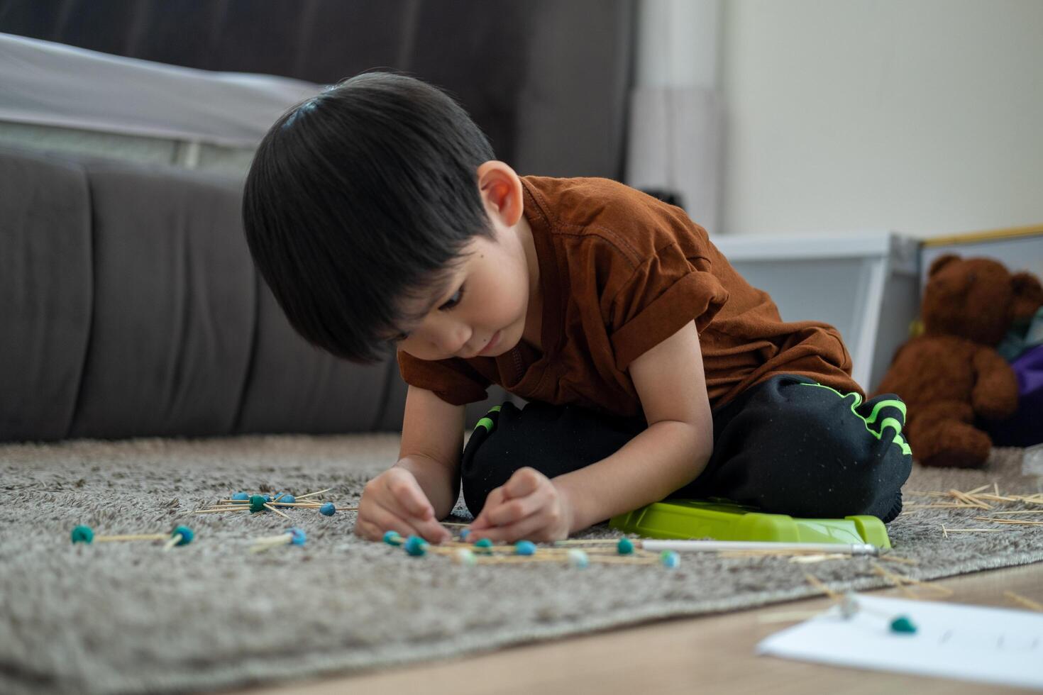 asiático chico jugando con arcilla de moldear en el habitación foto