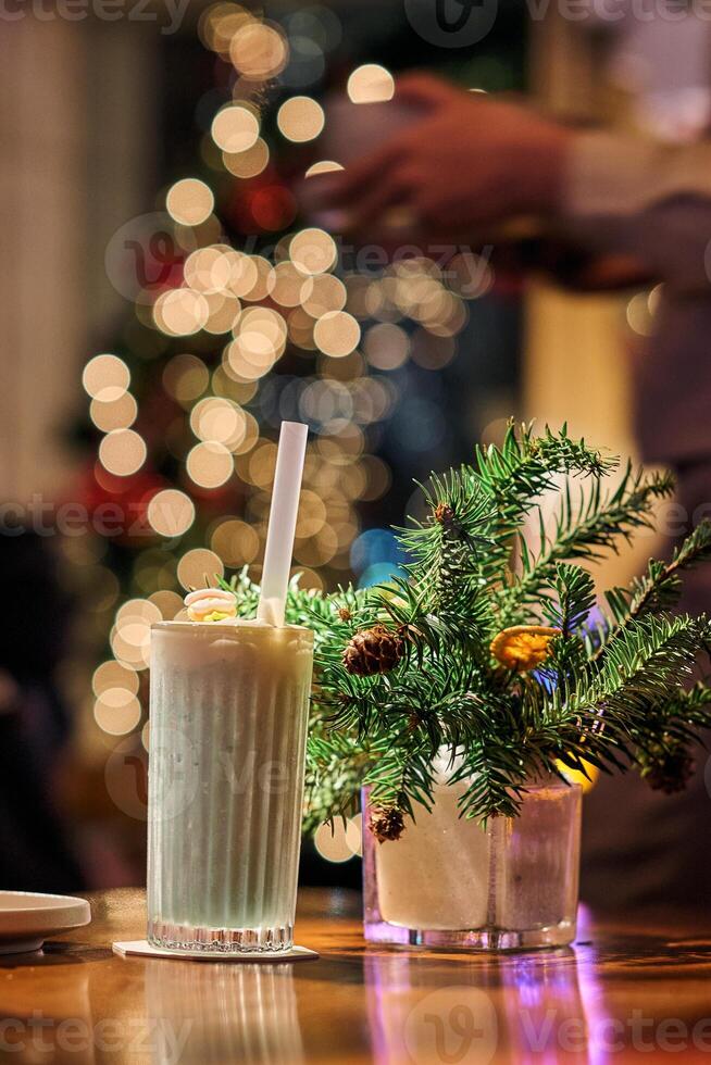 Smoothie in glass cups. Dark background with garland lights bokeh. Christmas and New Year sweet dfink and food holiday concept photo