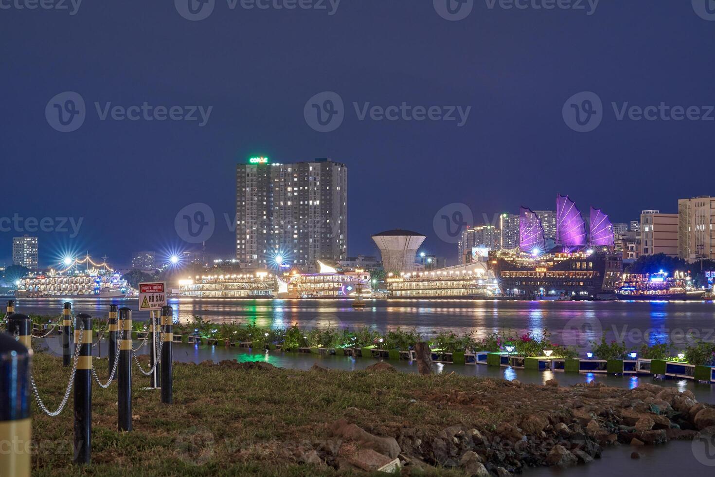 Ho Chi Minh City skyline and the Saigon River. Amazing colorful night view of skyscraper and other modern buildings at downtown. Travel concept photo