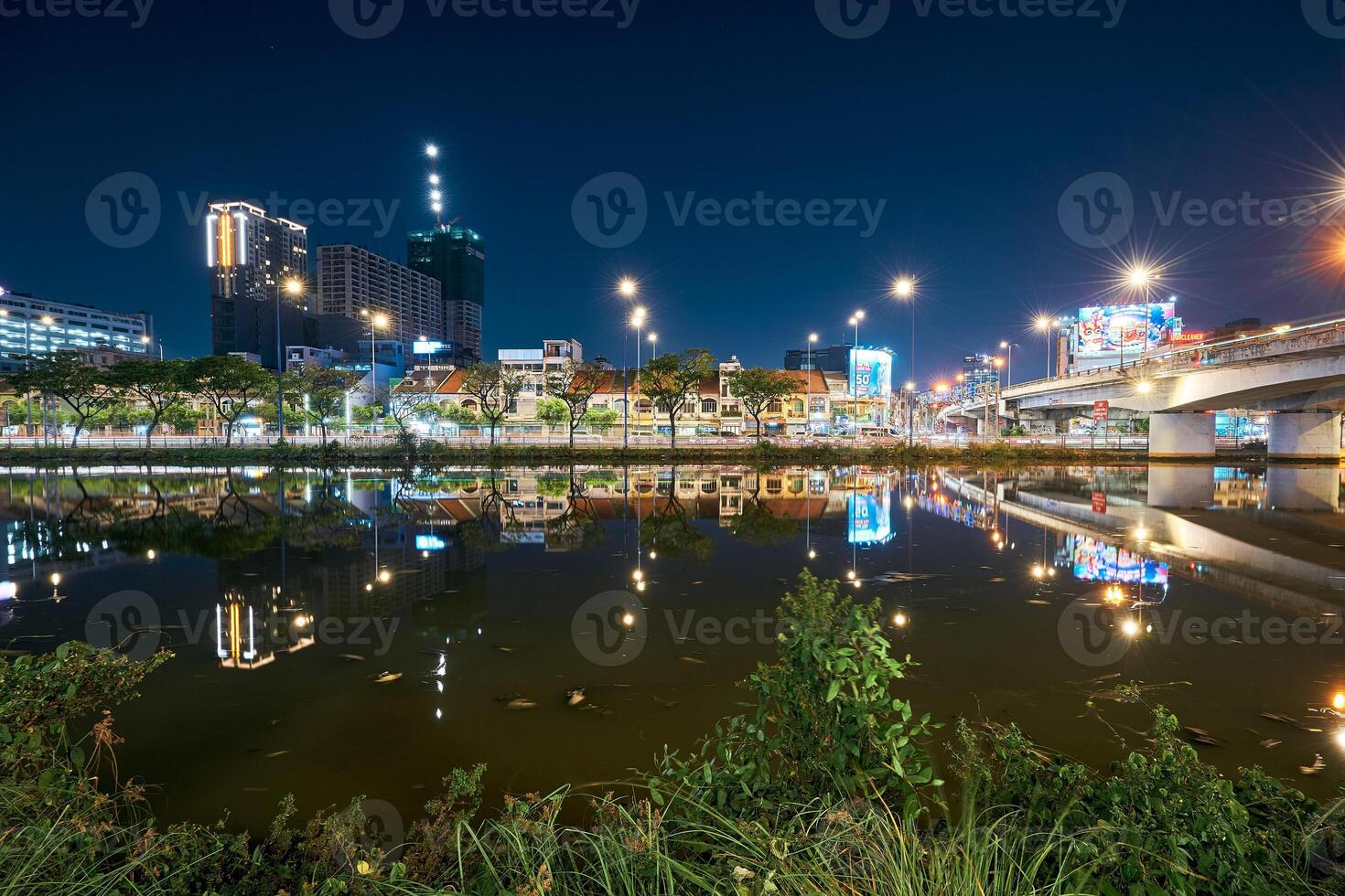 Ho Chi Minh City skyline and the Saigon River. Amazing colorful night view of skyscraper and other modern buildings at downtown photo