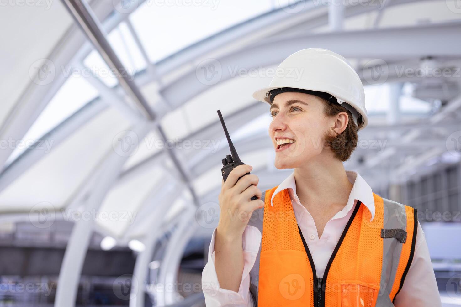Caucasian woman engineer is using walkie talkie while inspecting the construction project for modern architecture and real estate development photo