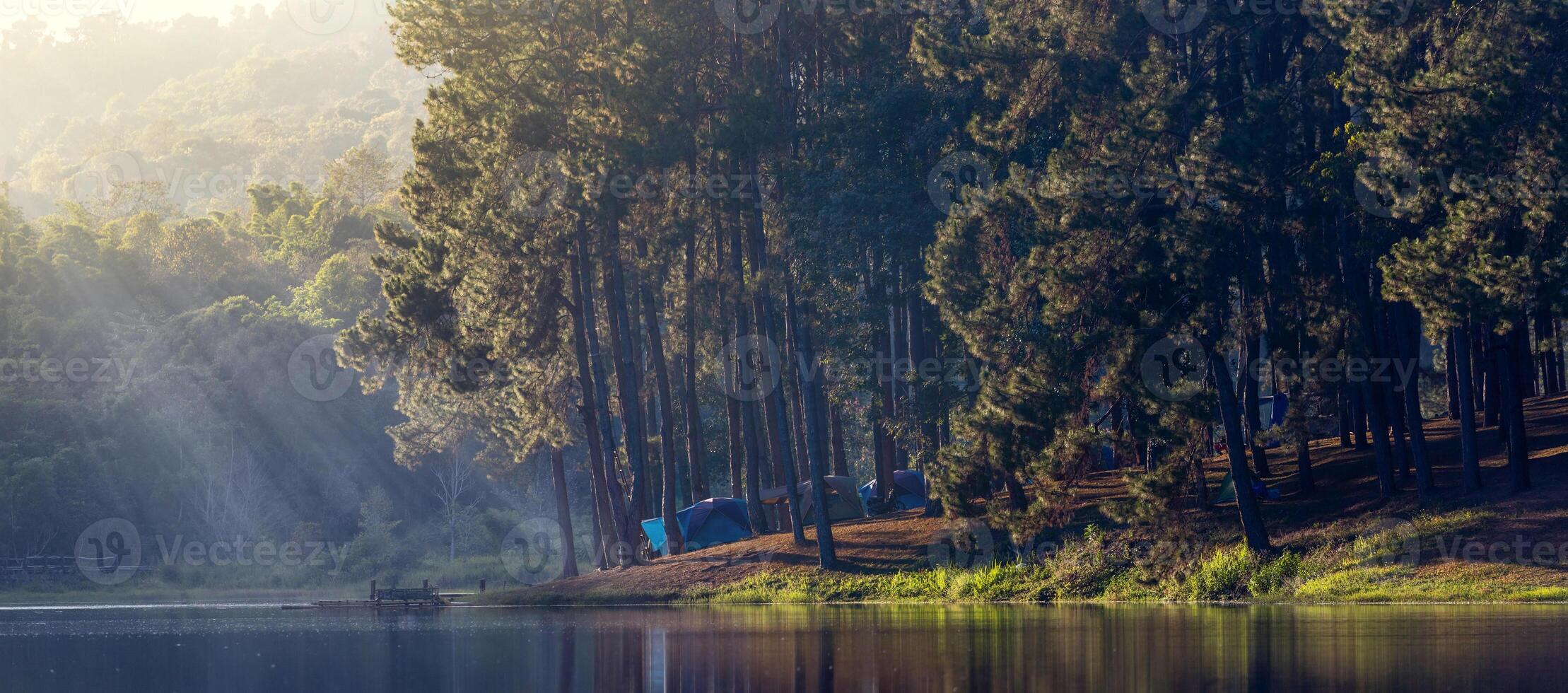 Group of tent for overnight camping with sunrise over the misty mountain and ray of light and campsite of Pang Oung, Mae Hong Son, Thailand photo