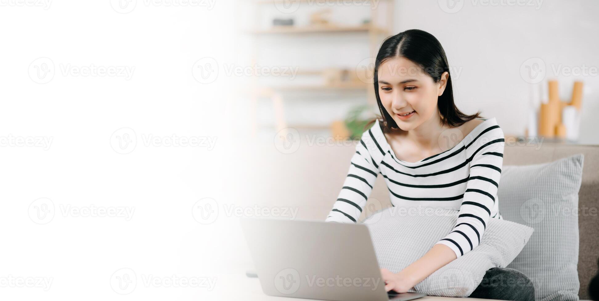 Asian woman using the smartphone and tablet on the sofa at home photo
