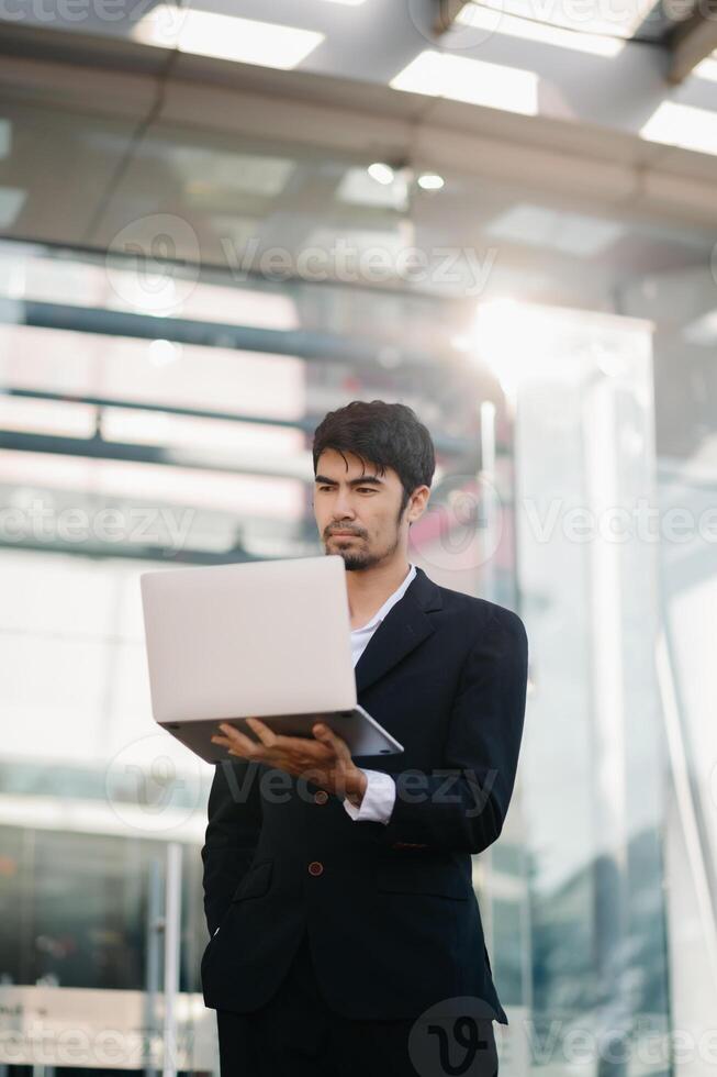 Handsome young businessman using a digital tablet outside an office building. photo