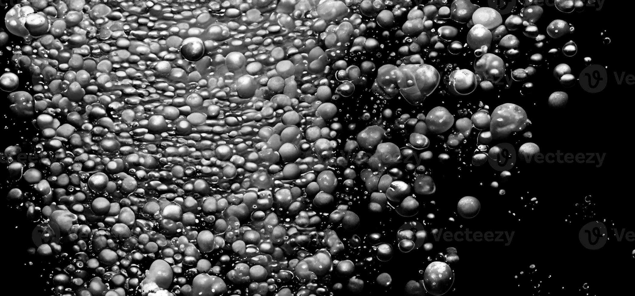 Soda water bubbles splashing underwater against black background. photo