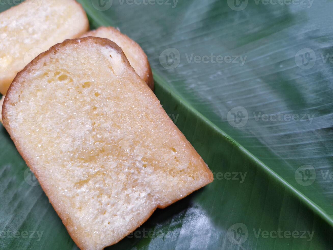 Picture of bread with butter, milk, sugar placed on a banana leaf. photo