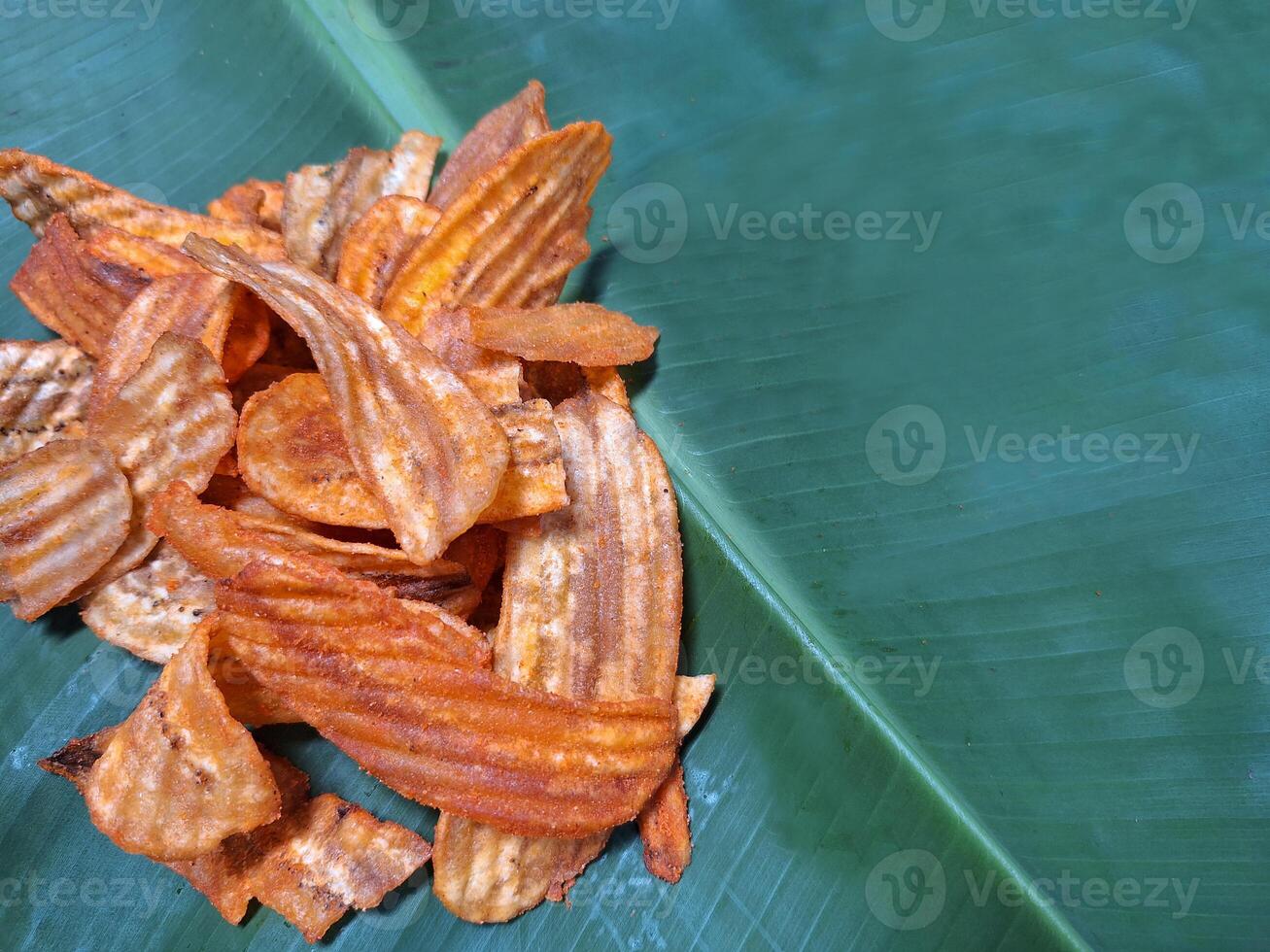 Picture of dried banana slices placed on banana leaves. photo