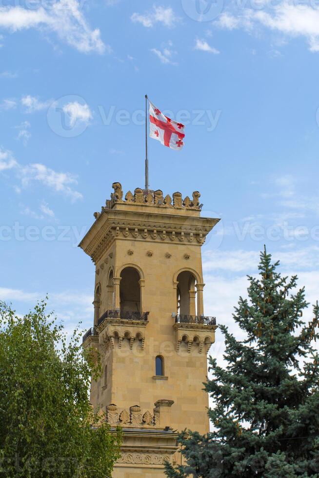 Georgia bandera en el techo de un antiguo torre en contra el claro azul cielo foto