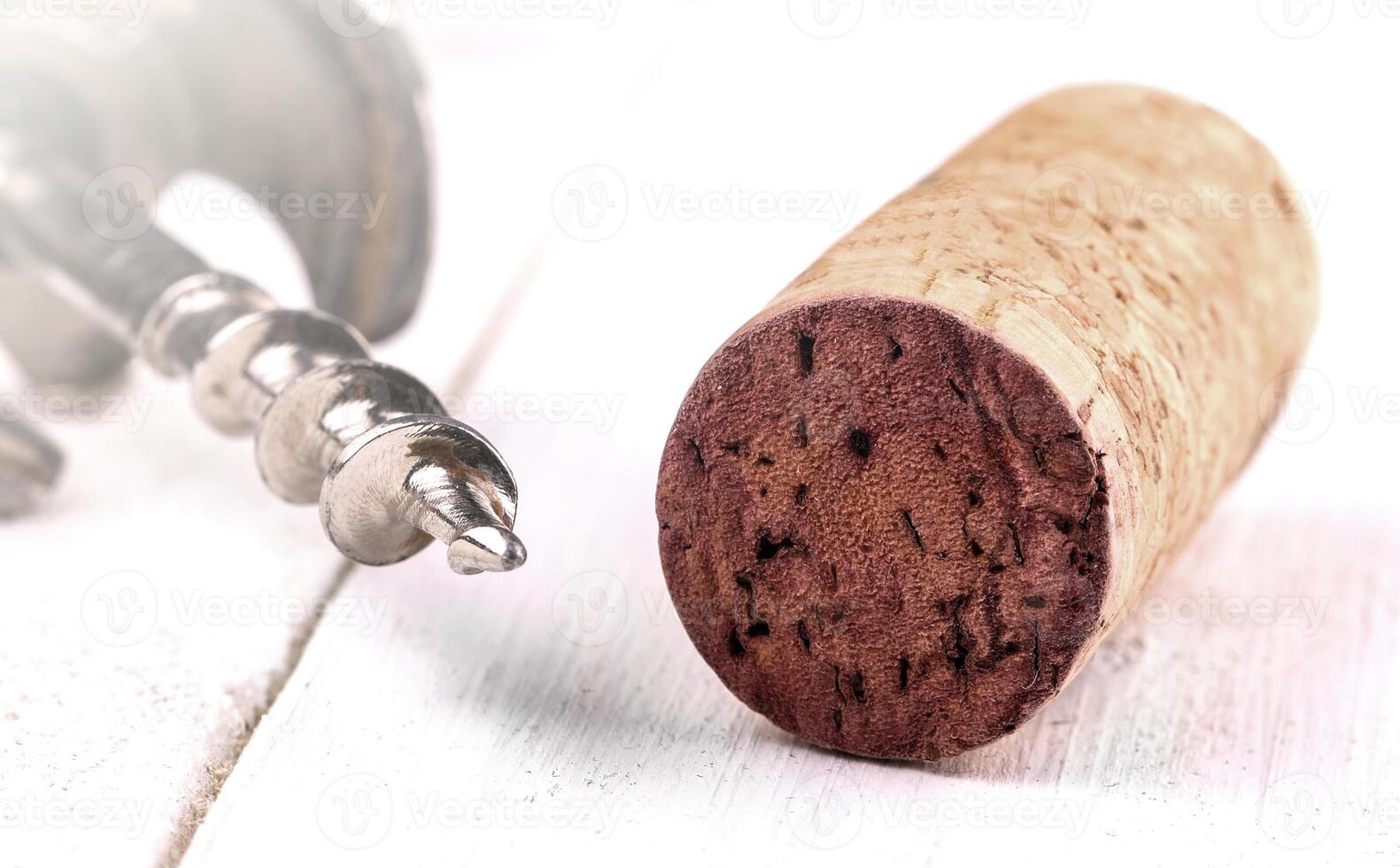 Wine cork and corkscrew on white surface on soft sunlight photo