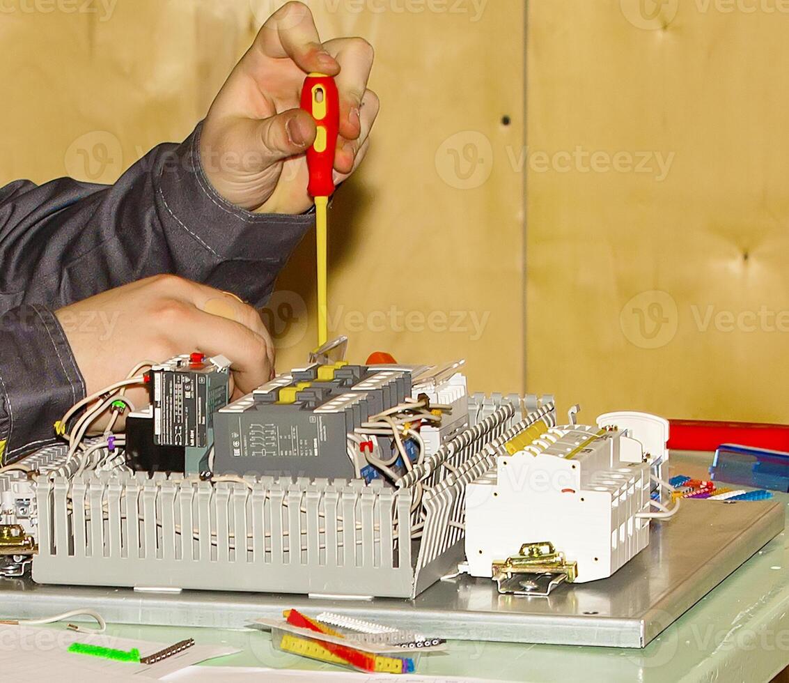 manos trabajando tornillo el parte en el medición dispositivo. foto