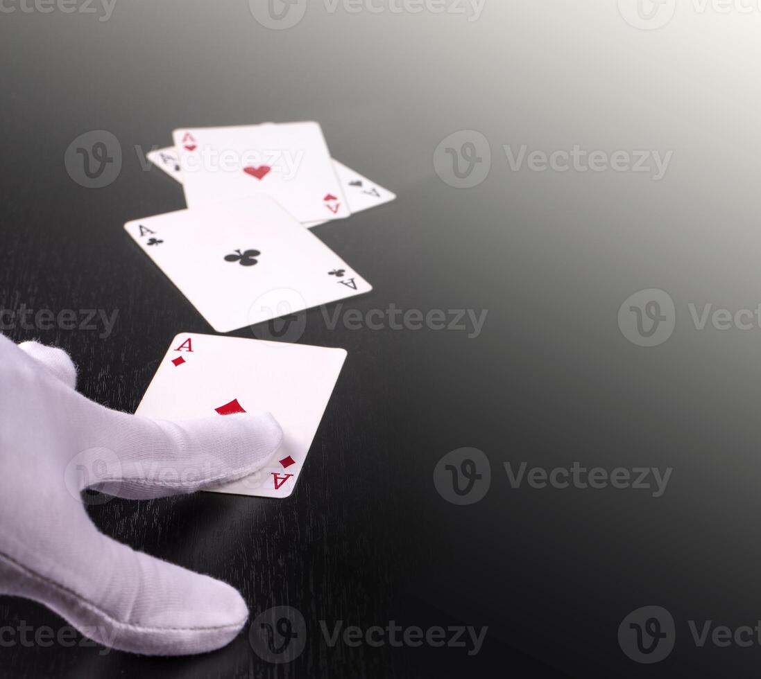 hand of the dealer in white gloves in a casino handing out cards photo