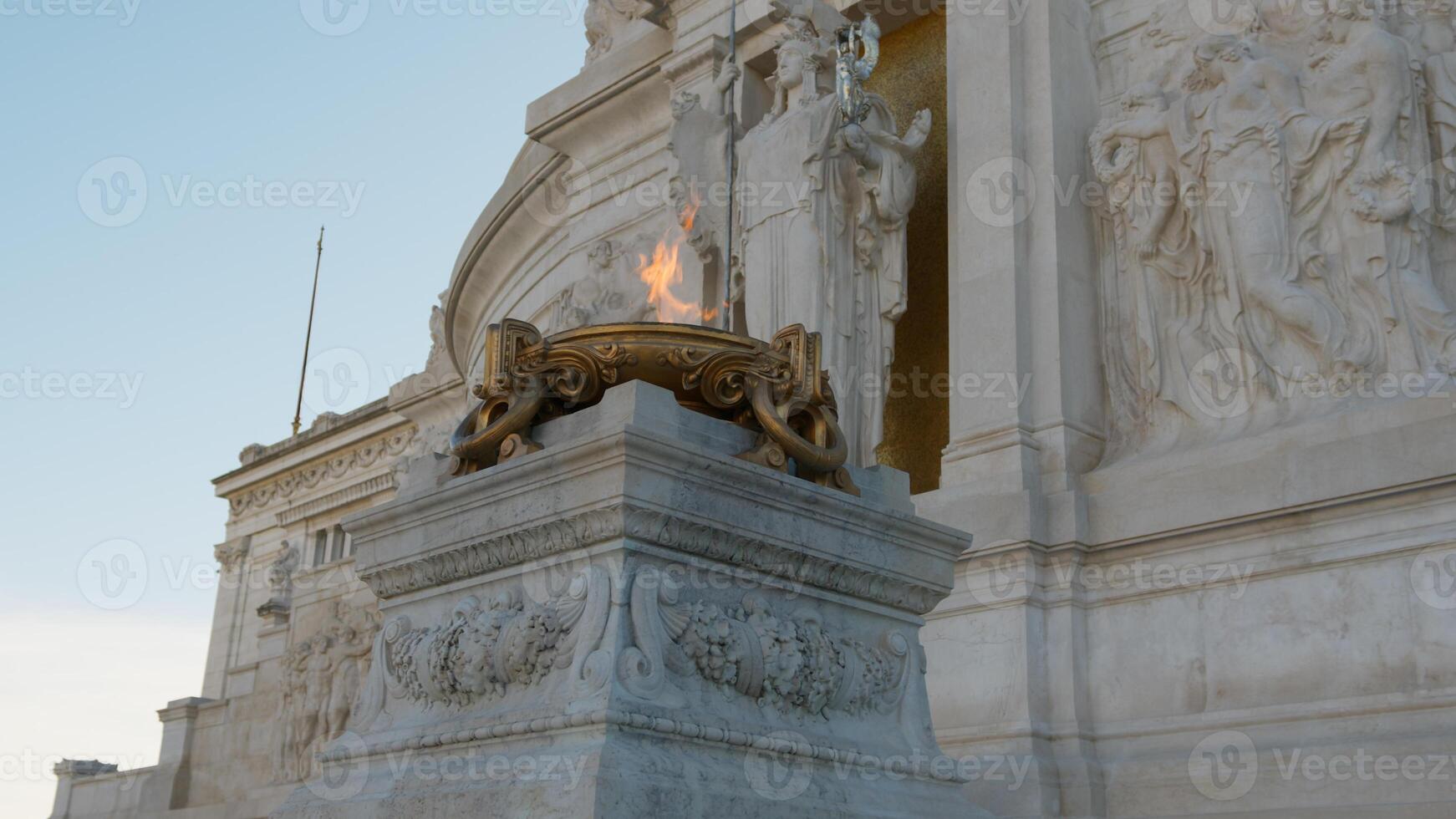 the flame of glory burning under a statue in Rome photo