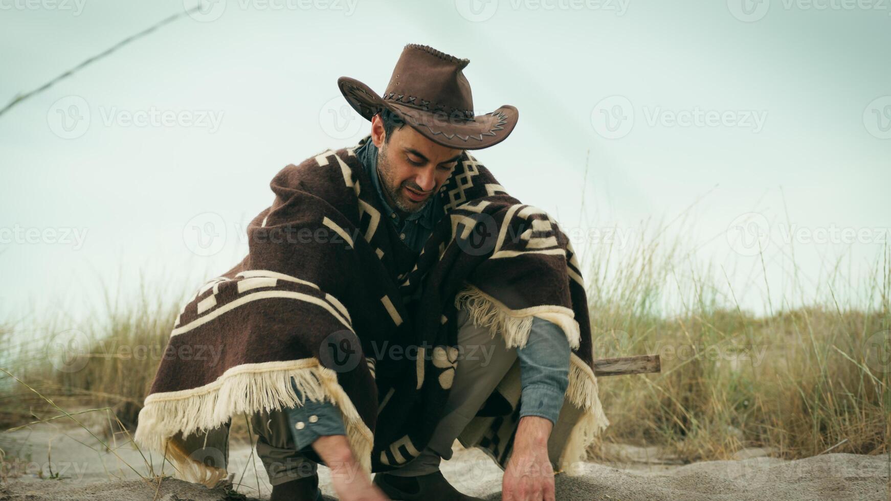 Man digs with his hands in the sand photo