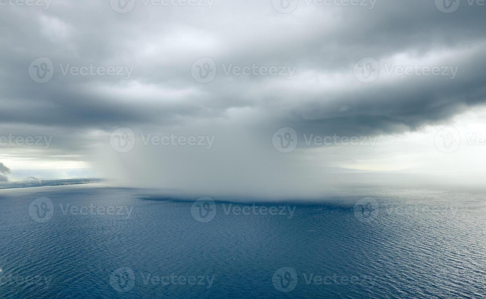 Cloudburst over the ocean near the coast photo