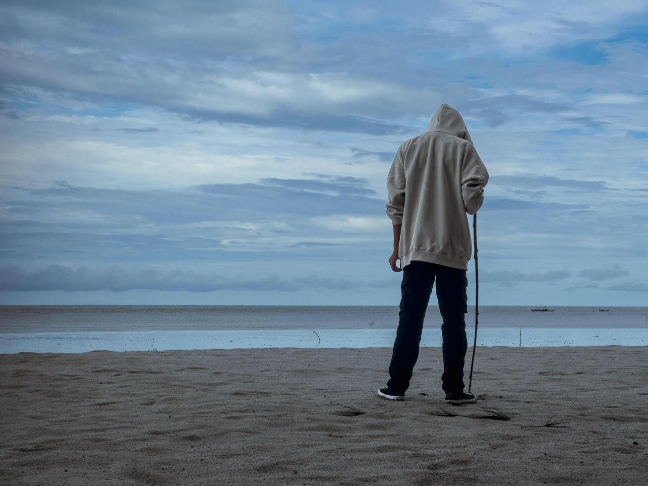 un hombre destacado firmemente con un palo en su mano. alguien quien piensa acerca de el futuro foto