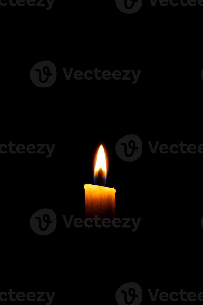 Burning White Candle on the dark, flame of candle on black background photo