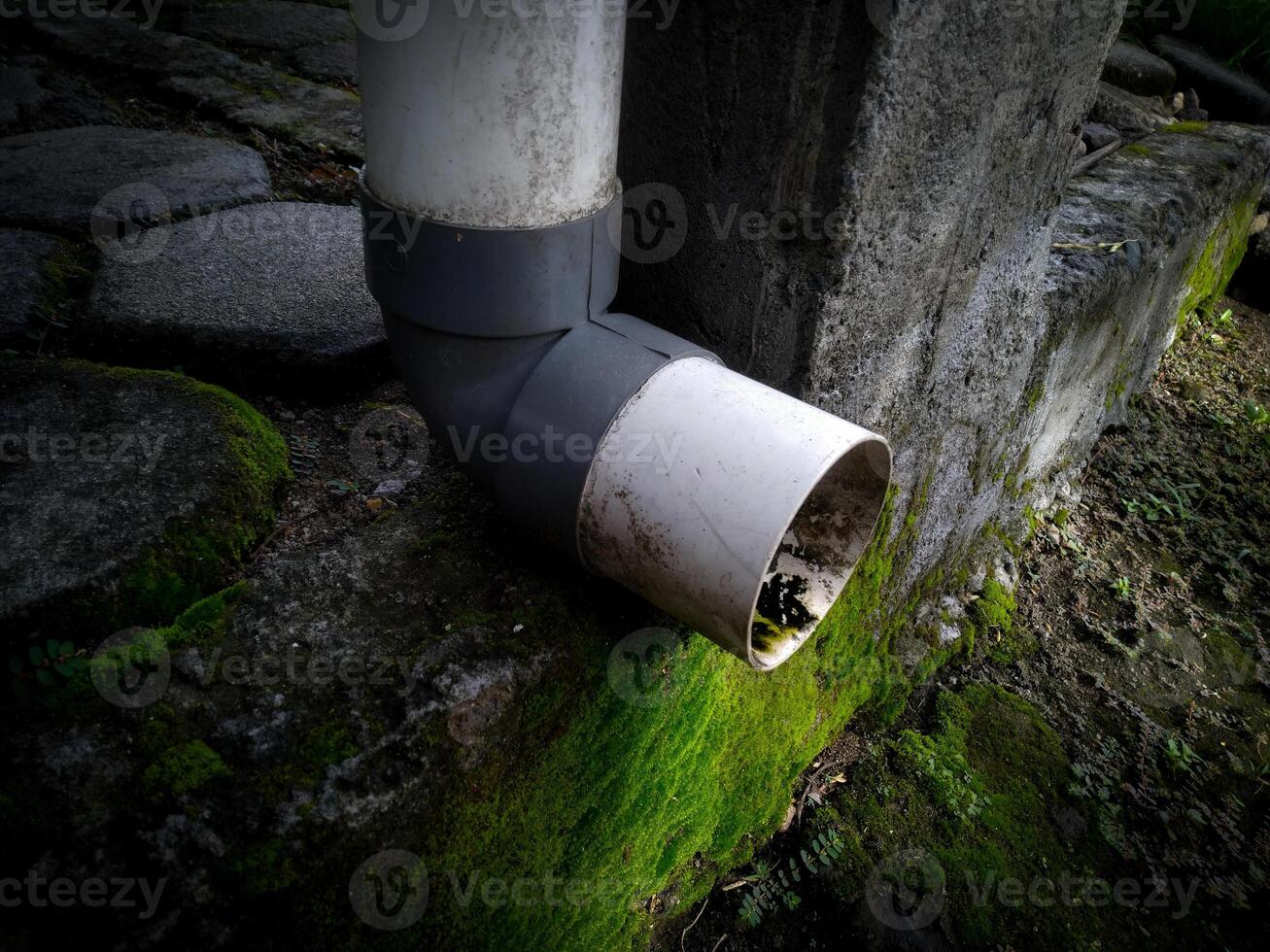 A plumbing of water drain from the rooftop with a dirty pipe photo