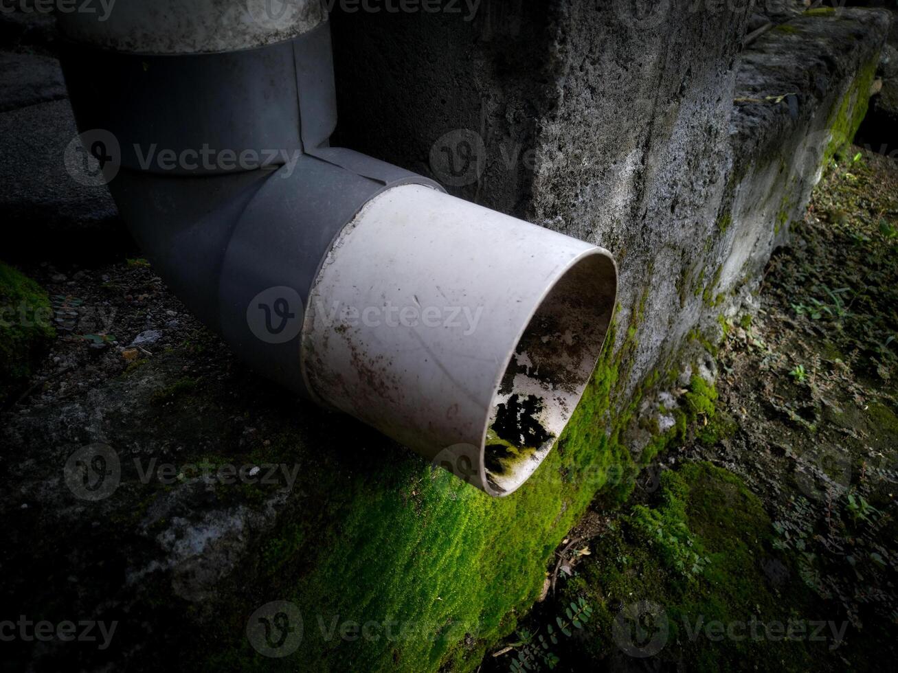 A plumbing of water drain from the rooftop with a dirty pipe photo