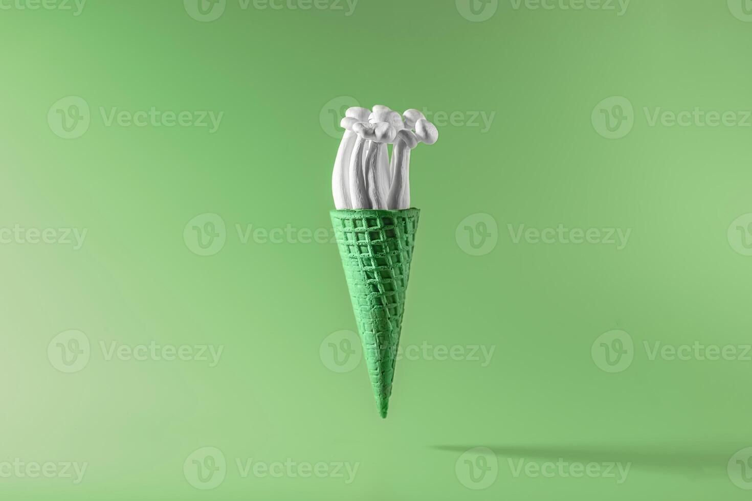 shimeji mushrooms with green moss in green ice cream cone, on green background photo