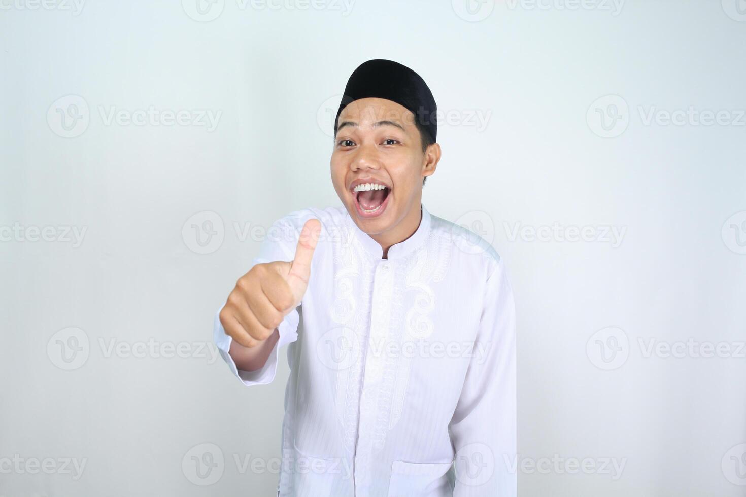 cheerful muslim asian man shouting while giving thumb up isolated on white background photo