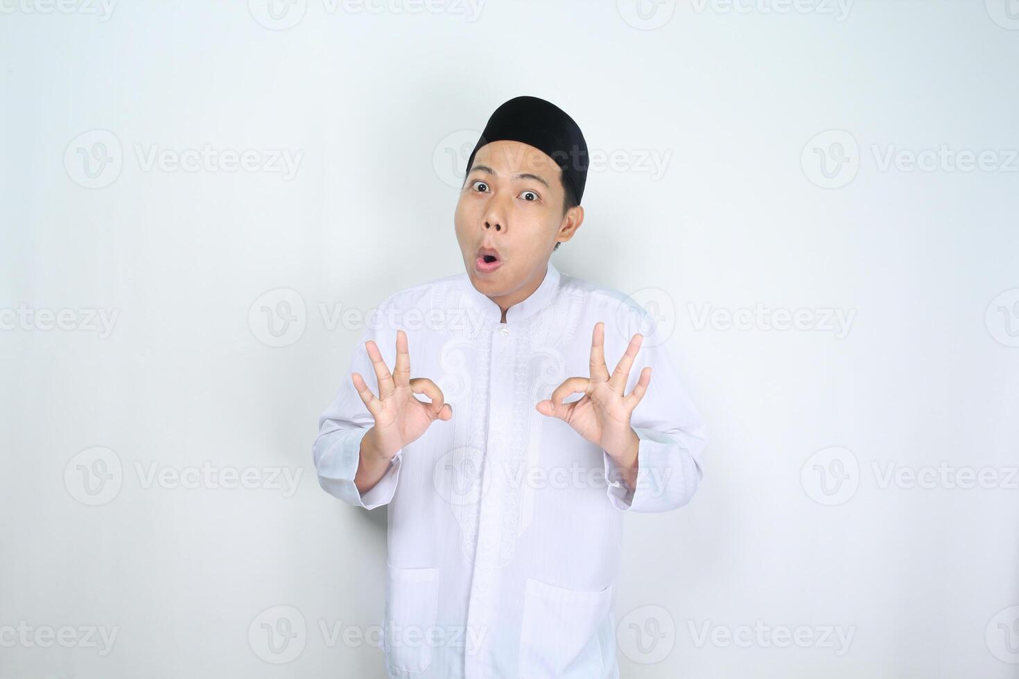 funny muslim man asian give okay signs with shocked expression isolated on white background photo