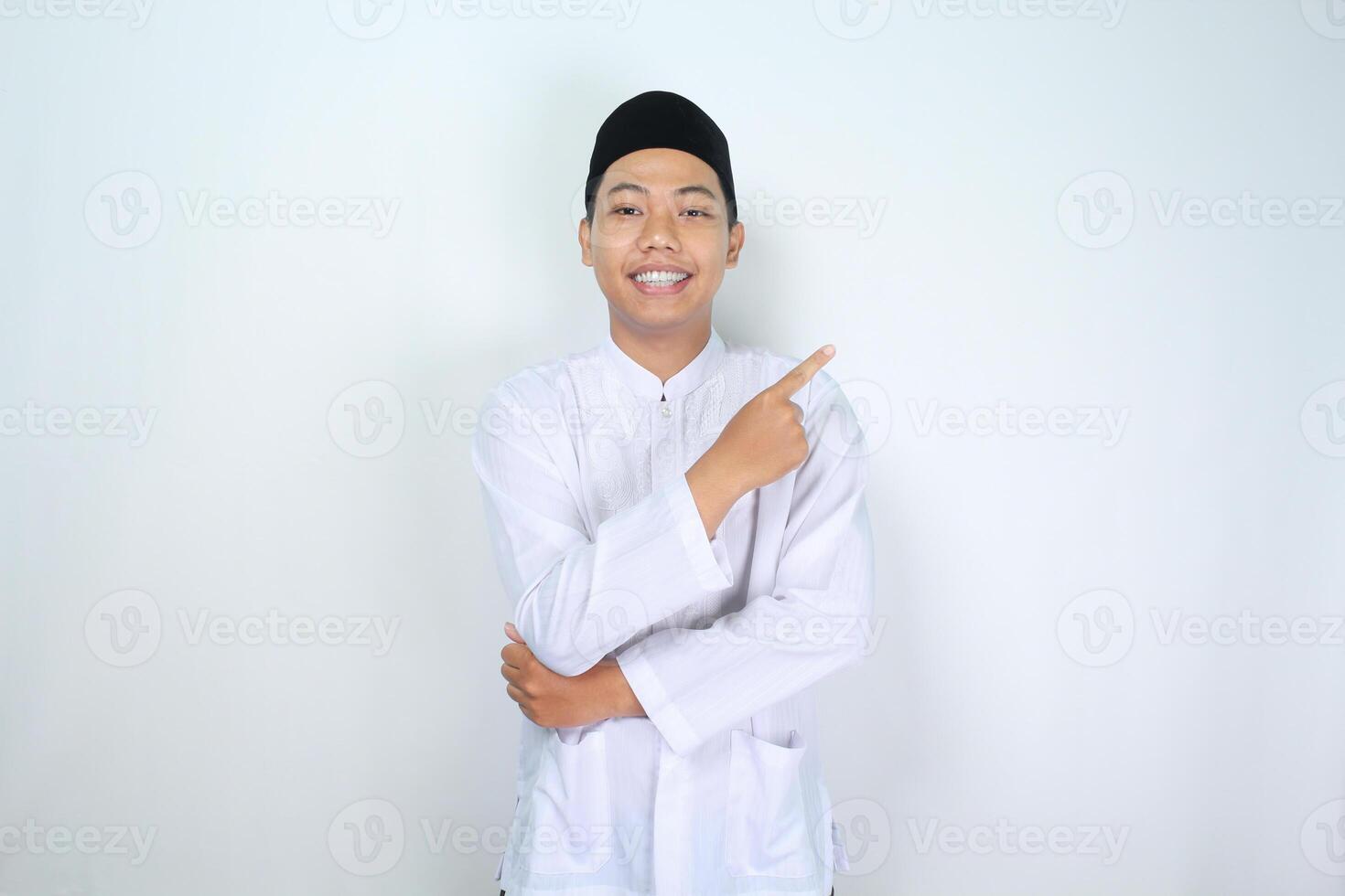 happy muslim asian man pointing to side isolated on white background photo