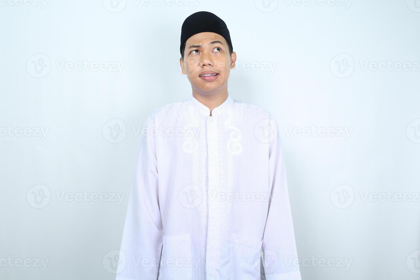 asian muslim man looking above with confused face isolated on white background photo