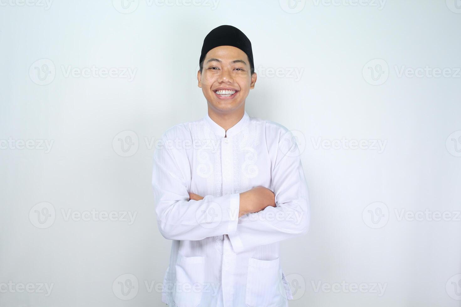 asian muslim man smiling at camera with folded arms isolated on white background photo