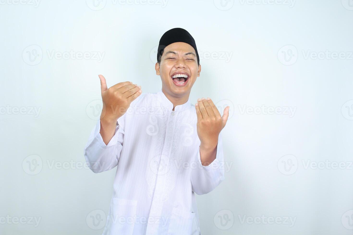 excited asian muslim man show inviting gesture with laugh isolated on white background photo