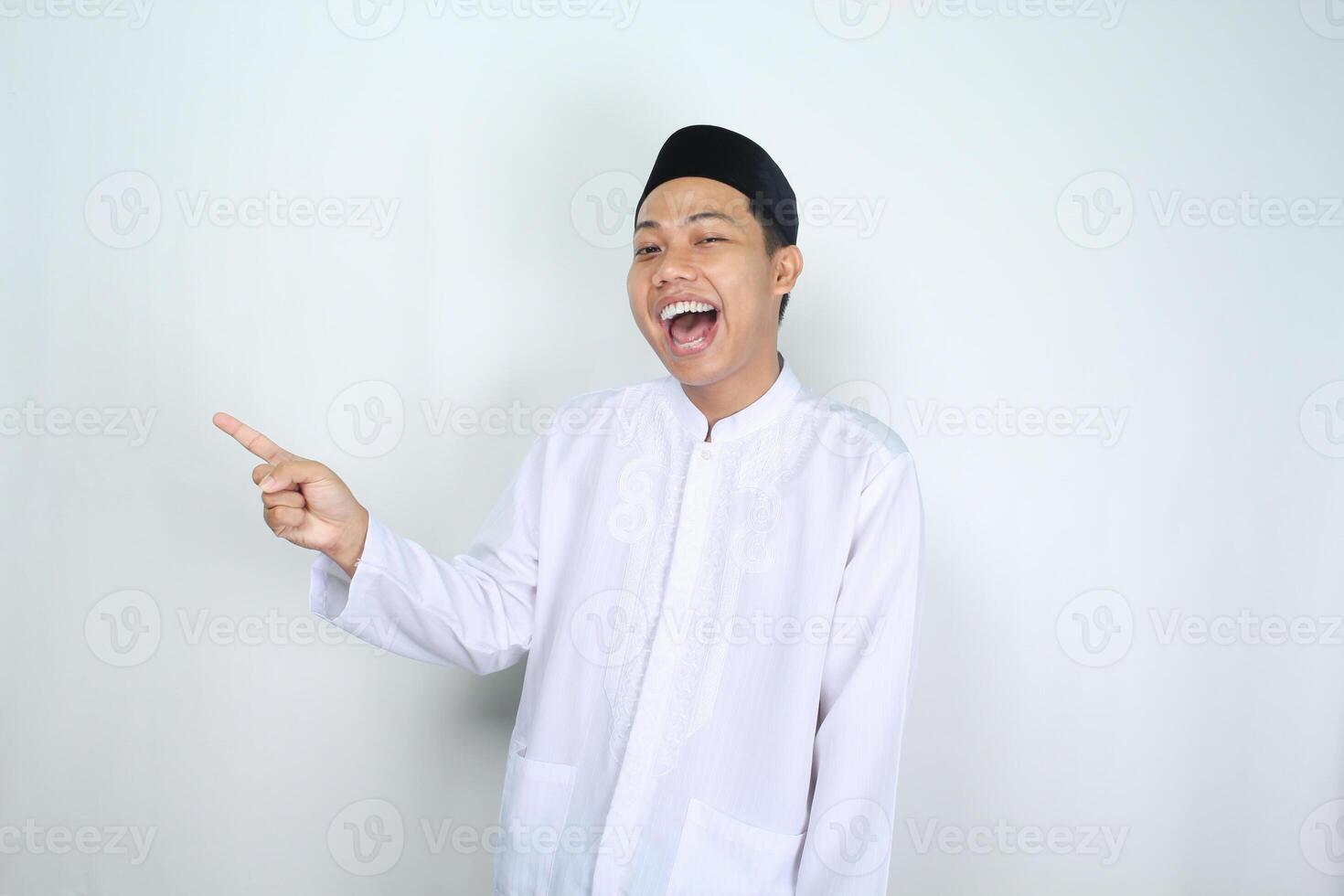 attractive muslim asian man pointing to the right side and shouting with mouth open isolated on white background photo