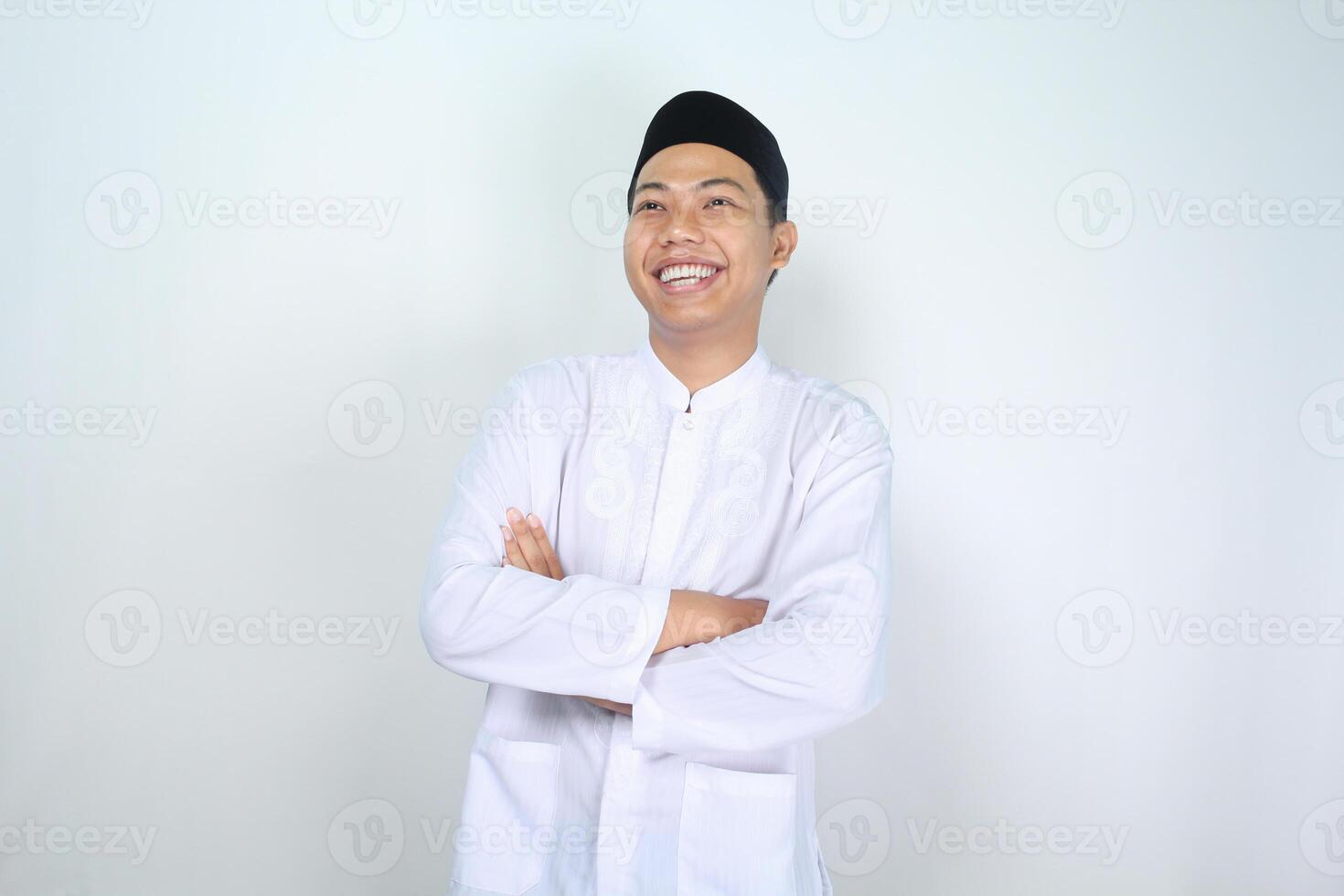 asian muslim man smiling with folded arms looking away isolated on white background photo