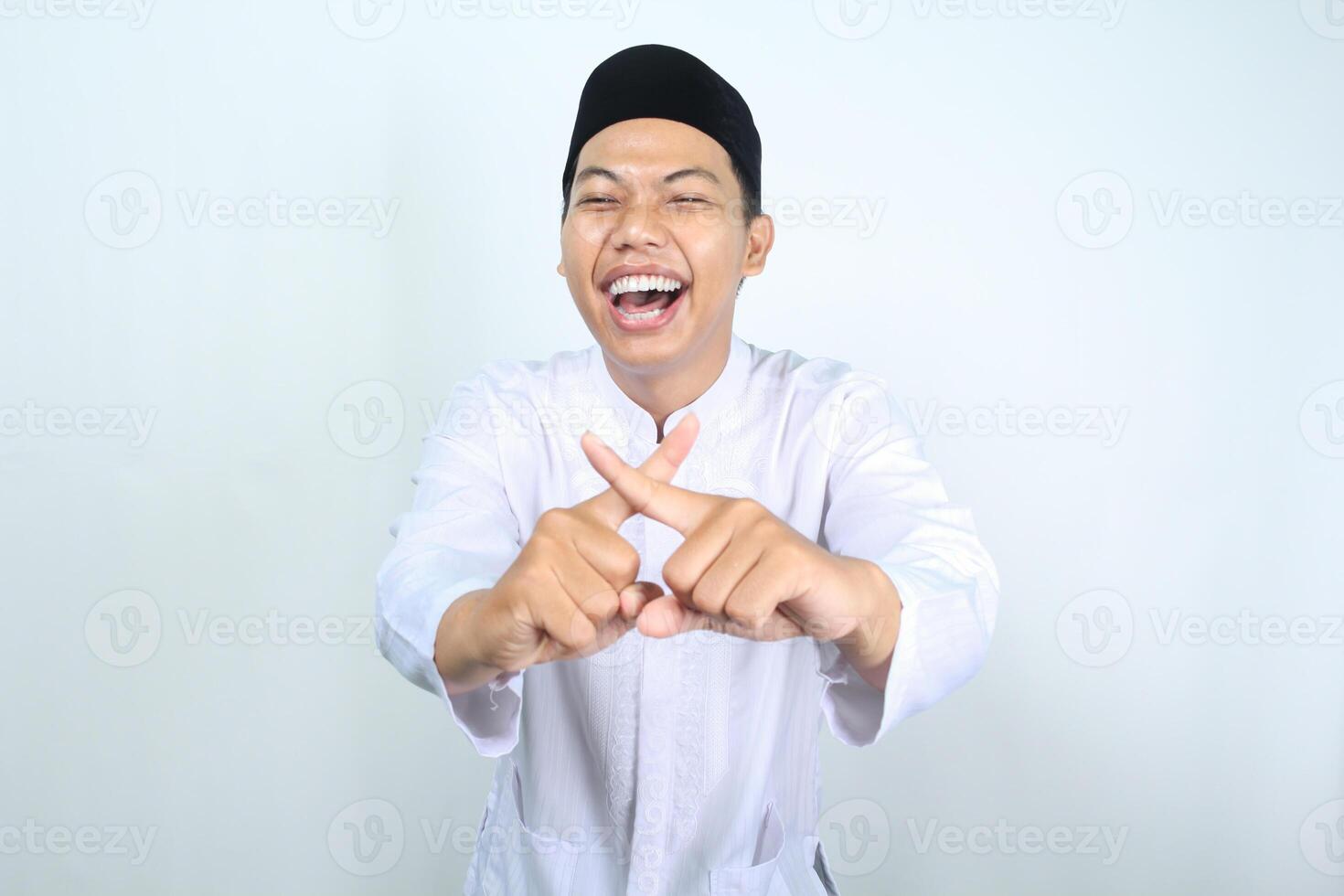 asian muslim man laughing with cross finger isolated on white background photo