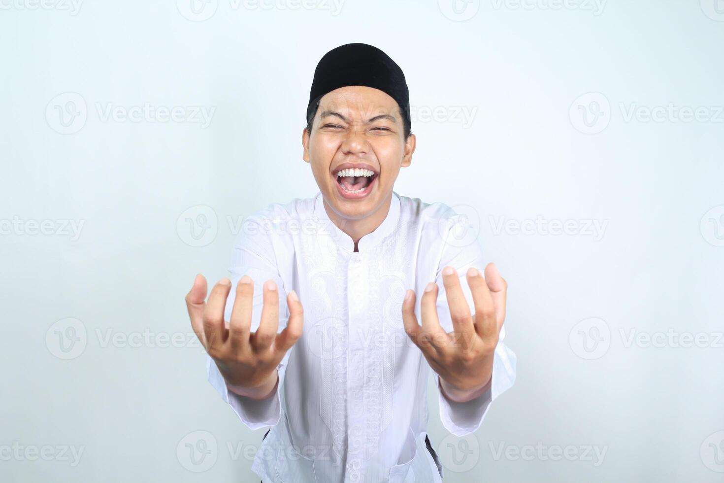 asiático musulmán hombre participación imaginario cuenco con vacío palma y riendo expresión aislado en blanco antecedentes foto