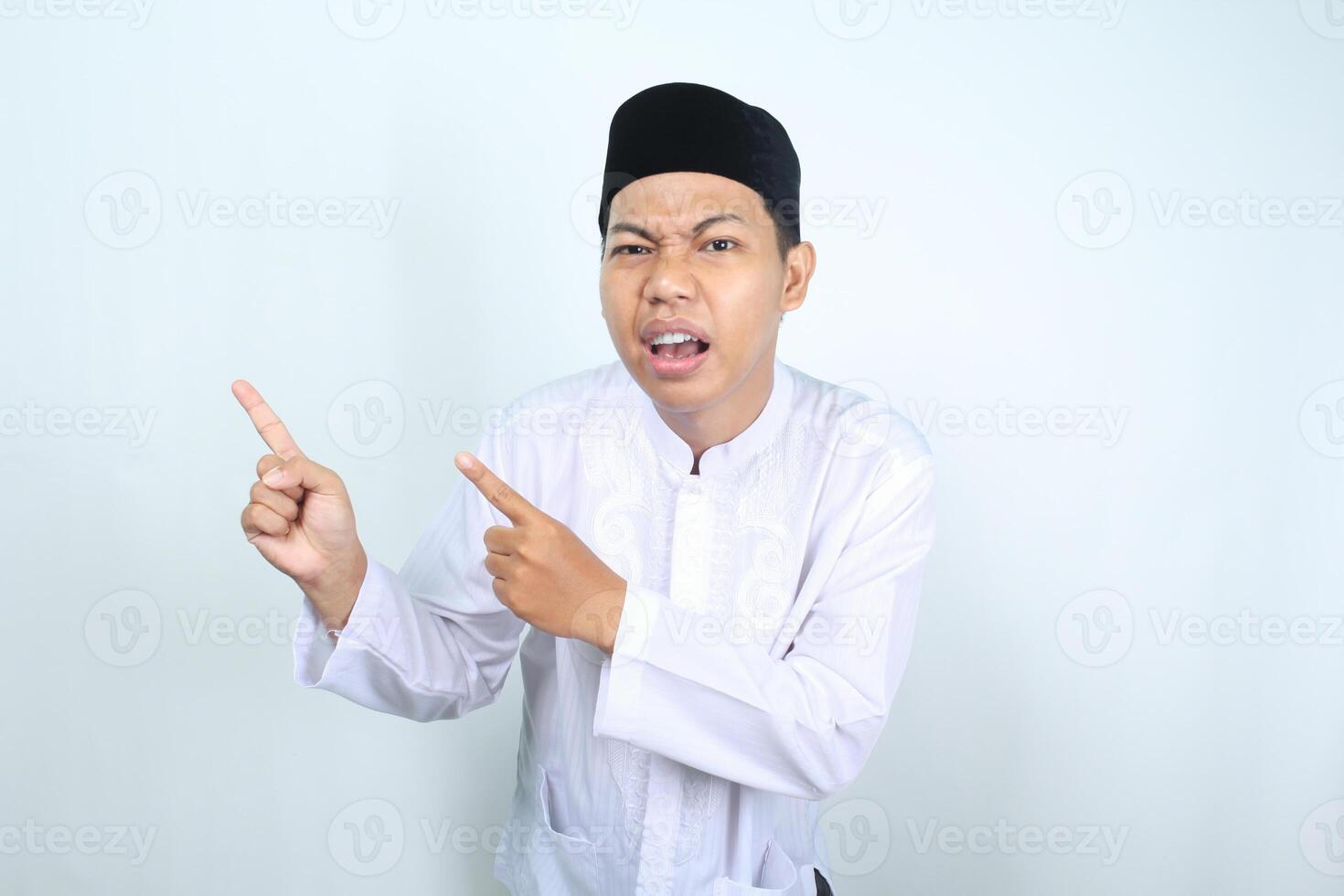 confused asian muslim man pointing to side isolated on white background photo