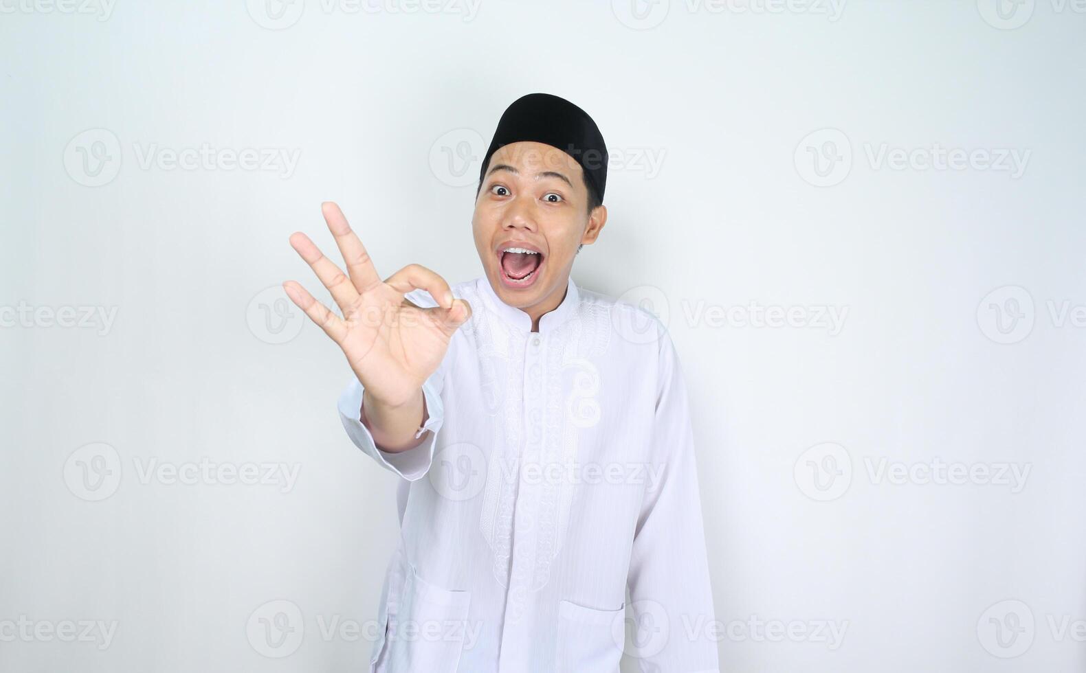funny muslim man asian give okay signs with surprised expression isolated on white background photo