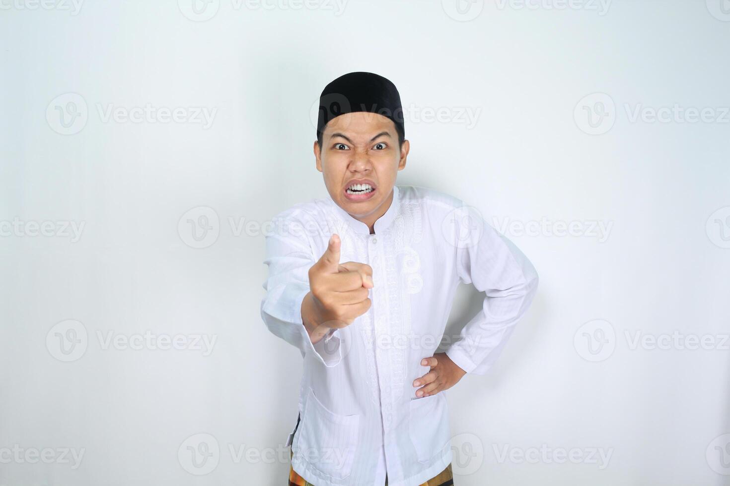 enojado musulmán asiático hombre señalando a cámara aislado en blanco antecedentes foto