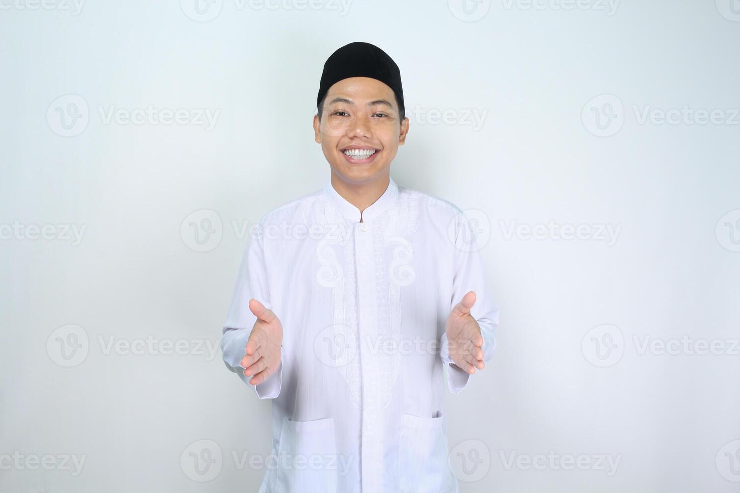 muslim asian man smiling looking at camera while holding imaginary box isolated on white background photo